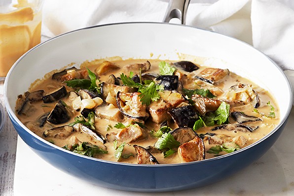 Aubergine Curry Recipe with Peanut and Coconut Bowl of creamy aubergine curry with a plate of forks at the side
