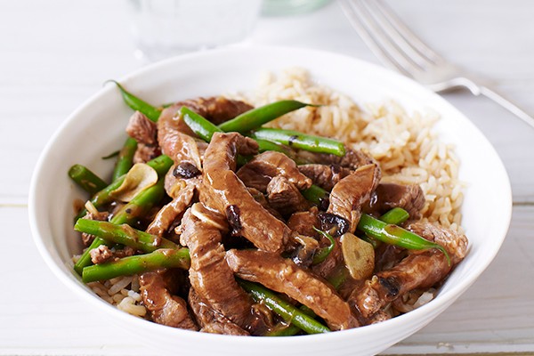 Big white bowl of Beef and Black Bean Stir-Fry with a silver fork