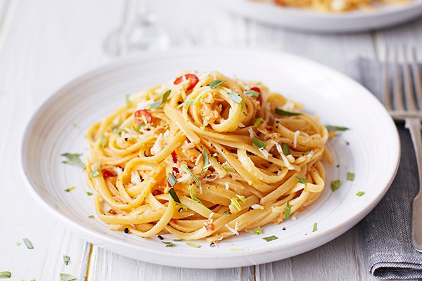 Two dishes of crab linguine topped with tarragon