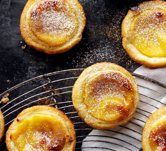 Portuguese custard tarts on a cooling rach