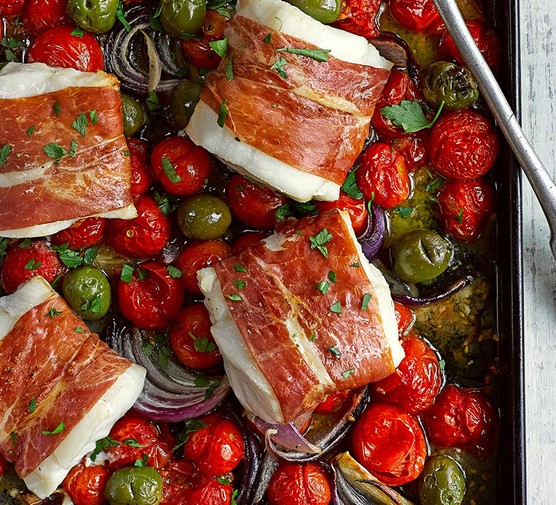 Baked cod loin with olives and tomatoes in a baking tray