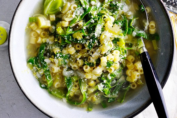 A bowl of Spring Vegetable Soup with Lemon served with a spoon in the bowl