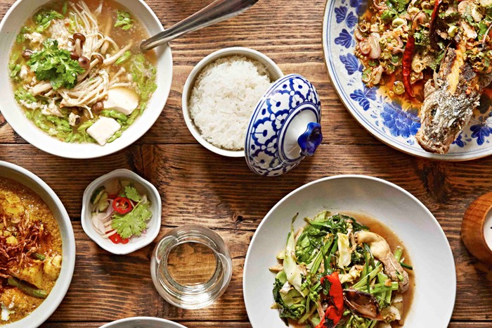 Overhead shot of Thai dishes on a wooden table at Somsaa