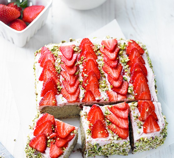 Traybake sponge topped with strawberries and pistachios