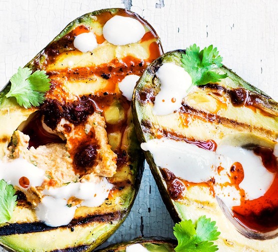 Grilled avocado halves with harissa hummus and tahini yogurt