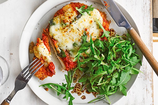 Chicken in parmesan and tomato sauce on a plate with salad