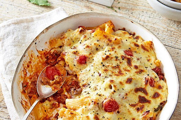 Pastitsio in a serving bowl, with spoon