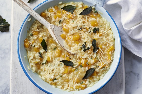 A pot of butternut squash risotto with sage leaves