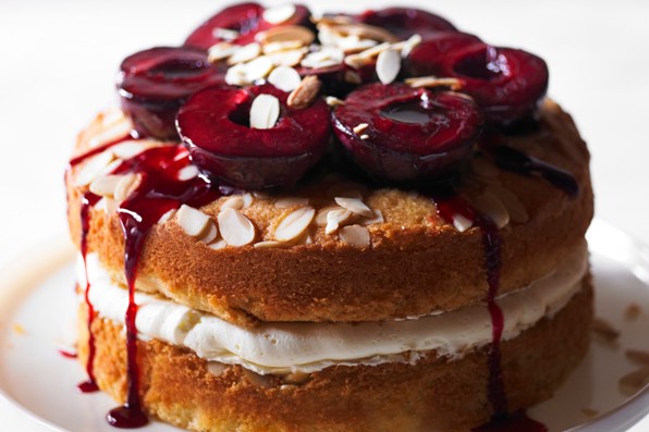 Sloe gin cake with plums Layer cake topped with plums, on stand