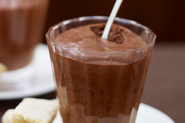 Chocolate mousse in a glass serving jar with orange shortbread on the side