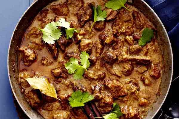 Pan of lamb rogan josh topped with coriander