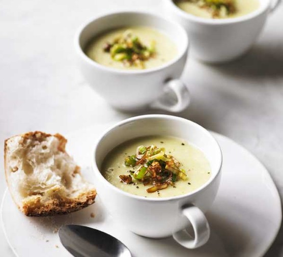 Three cups of leek and potato soup, topped with croutons