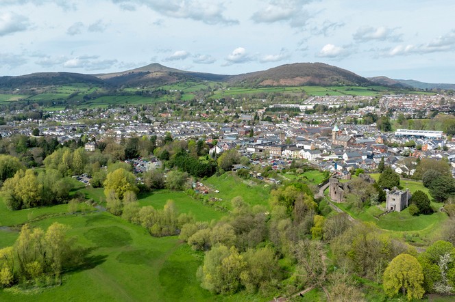 Aerial view of the historic town of Abergavenny and the landmark known as Sugar Loaf Mountain in Monmouthshire, South Wales, UK