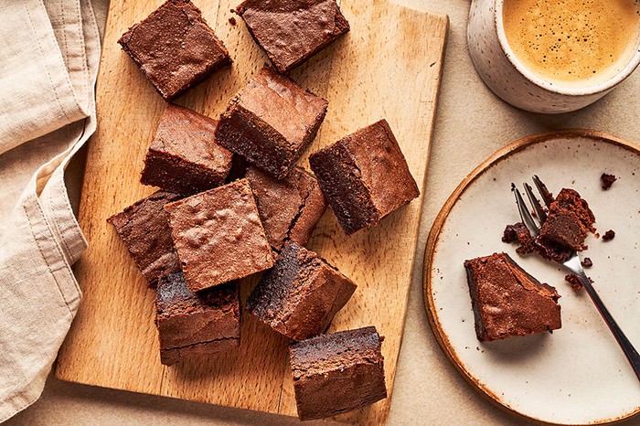 A pile of chocolate brownies on a chopping board