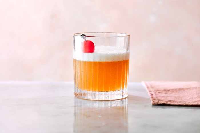 Amaretto sour An amaretto sour in a tumbler topped with a cherry, with a napkin on the side