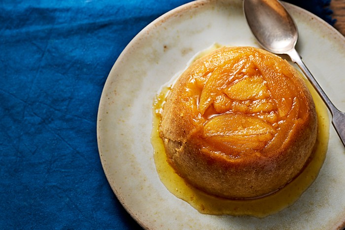 Steamed apple sponge and bay custard A steamed apple sponge on a plate
