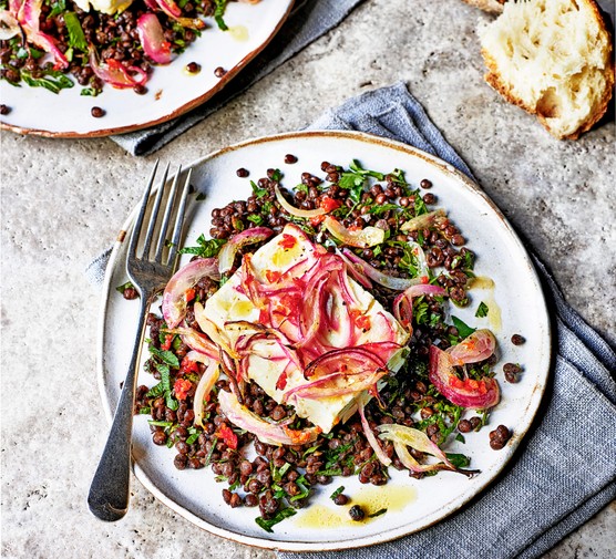 Lentil Salad Recipe with Feta and crunchy bread. Served on a white plate with a blue napkin on a grey table.