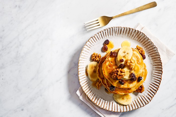Banana bread pancakes A stack of pancakes with raisins, walnuts and banana