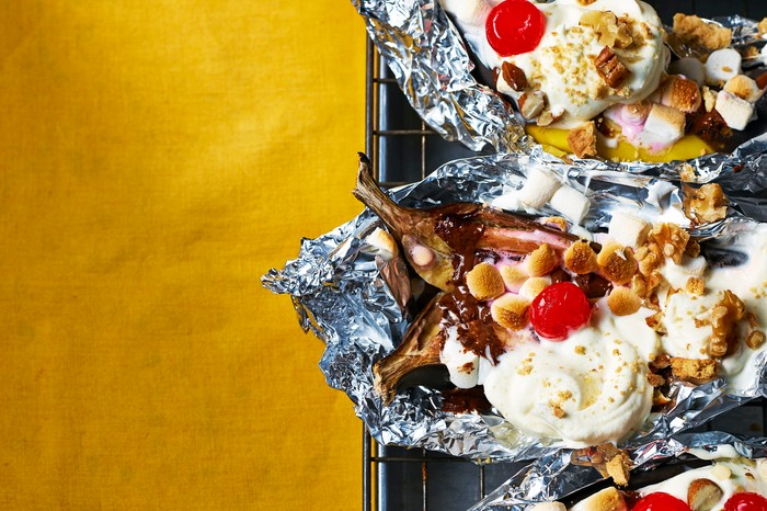 blackened banana split s'mores in foil parcels with a yellow background