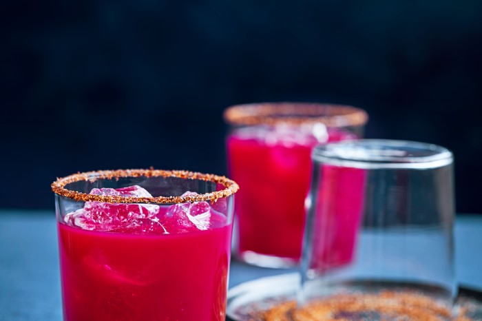 Two short glasses filled with beetroot mezcalita with salt on the rim