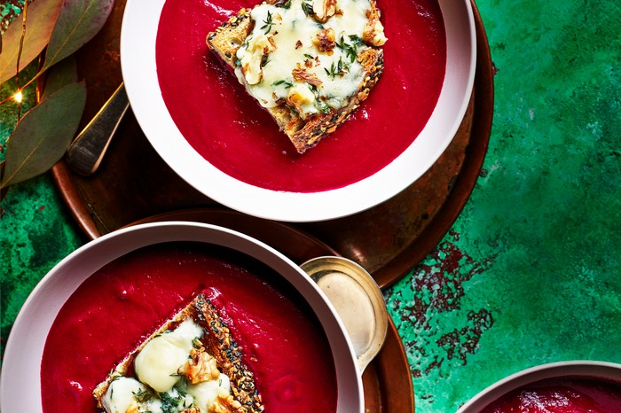 Two bowls of beetroot soup, topped with sourdough toast and blue cheese