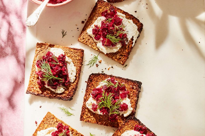 Individual toasts with ricotta and beetroot against a cream background