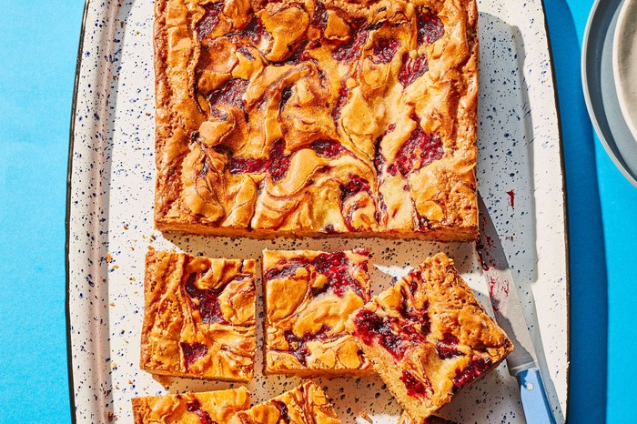 Blackberry blondies cut into squares against a blue background