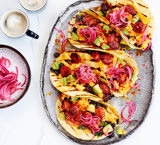 A tray of breakfast tacos holding scrambled egg, chorizo and beans