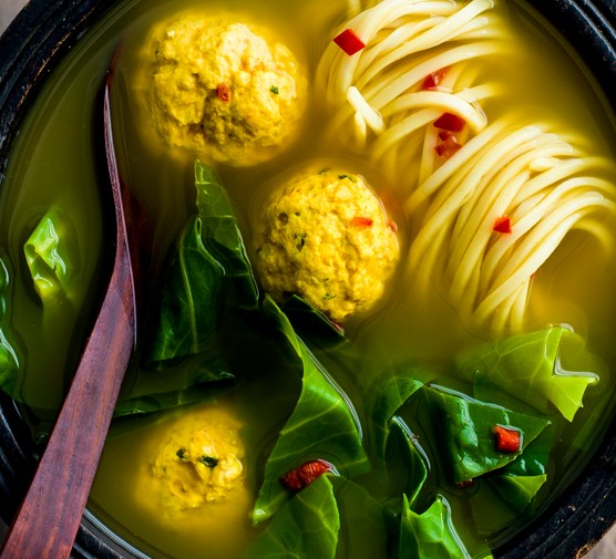 Bowl of turmeric broth with chicken and ginger dumplings