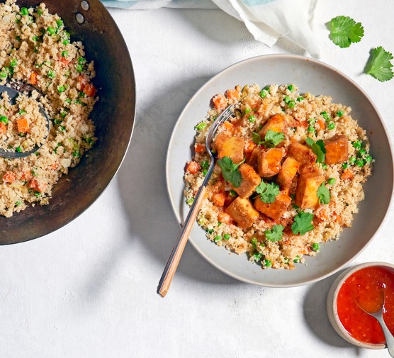 Bowl of Cauliflower Fried Rice with Crispy Baked Tofu and Chilli Sauce on the Side