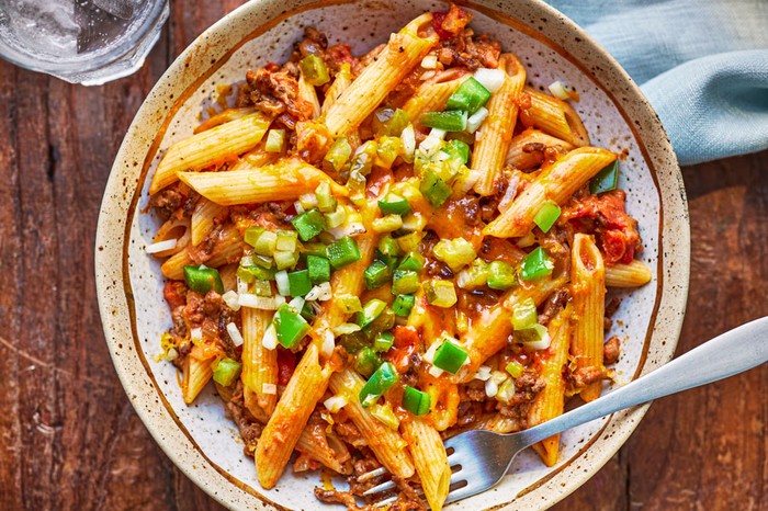 Beef tomato pasta topped with pickled cucumbers and green peppers