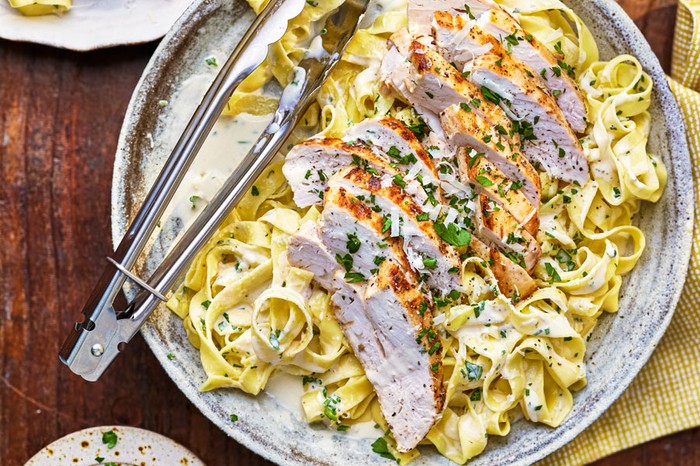 Sliced chicken on creamy tagliatelle