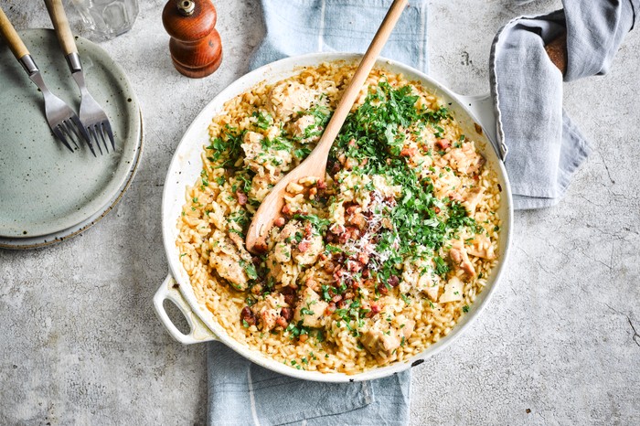 A risotto in its cooking pan with herbs on top