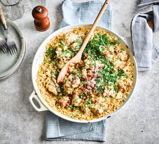 A risotto in its cooking pan with herbs on top