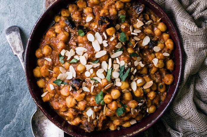 A bowl of chickpea stew with spices, topped with flaked almonds