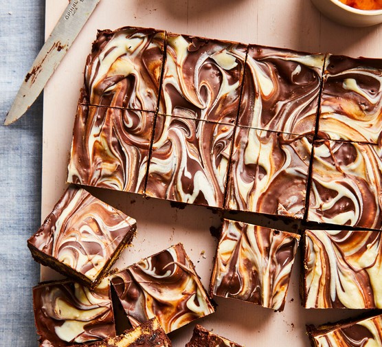 A tray of chocolate tiffin with swirled white chocolate and normal chocolate topping