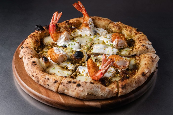 A neapolitan pizza topped with mozarella and panko tempura prawns