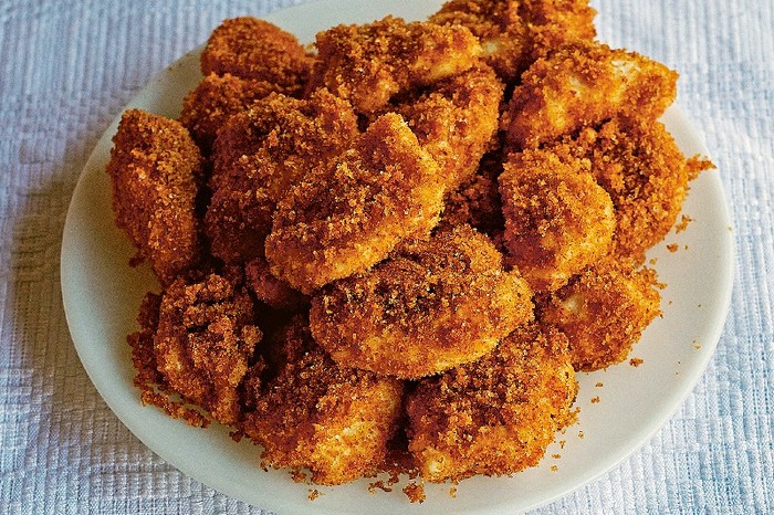 A white plate biled with golden crumbed curd cheese and semolina dumplings