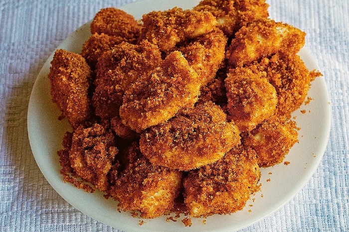 Curd cheese and semolina dumplings A white plate biled with golden crumbed curd cheese and semolina dumplings
