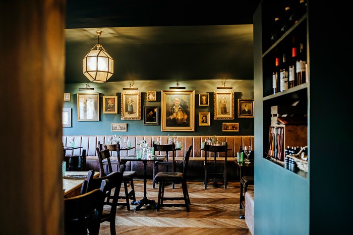 The Gin Trap Inn's restaurant, including dark wooden tables and vintage portraits