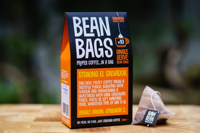 An orange and black cardboard pack of coffee bags