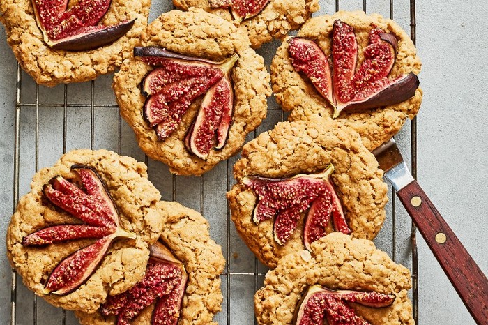 A wire rack topped with fig cookies on a grey background