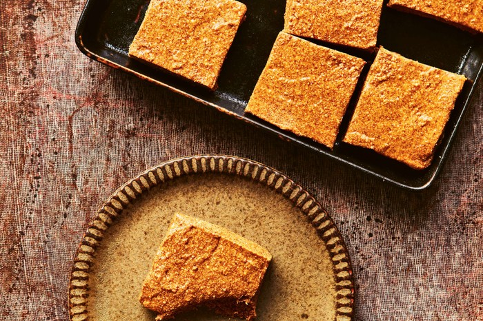 Peanut bars sliced into squares with one slice on a plate