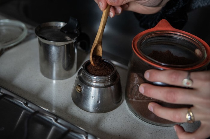 Italian Coffee Guide, Photo by Getty Sara Mancabelli prepares a coffee using loose grinded coffe beans and a moka pot