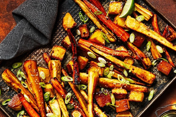 A tray of Gochujang-roasted root veg with a black kitchen cloth