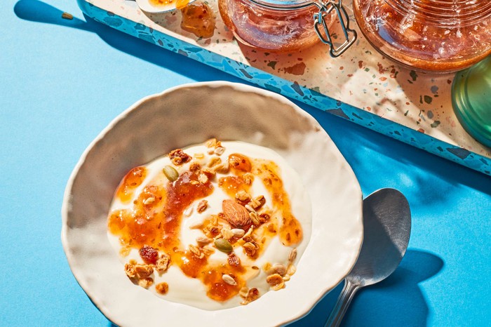 Gooseberry jam and granola on top of yogurt in a bowl