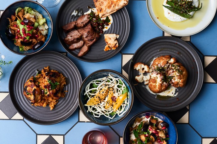 A range of Syrian sharing plates on a blue table and white patterned table