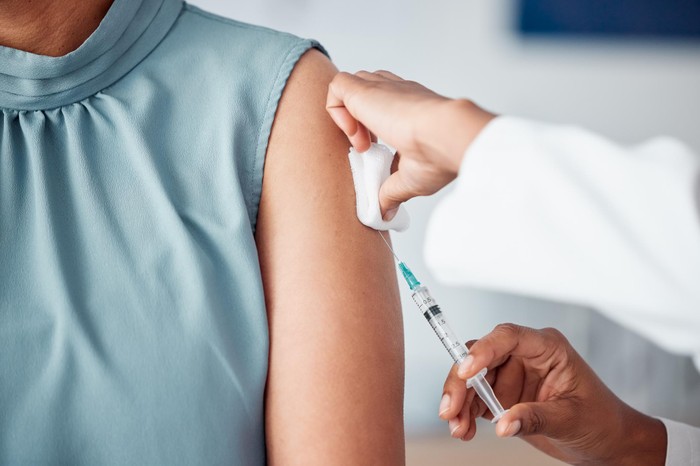 Hands, medical and doctor with patient for vaccine in a clinic for healthcare treatment for prevention. Closeup of a nurse doing a vaccination injection with a needle syringe in a medicare hospital. Hands, medical and doctor with patient for vaccine in a clinic for healthcare treatment for prevention. Closeup of a nurse doing a vaccination injection with a needle syringe in a medicare hospital.