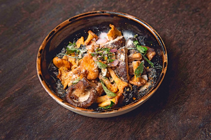 Kiln Soho Mushroom dish Small bowl of wild mushrooms with green leaves on top