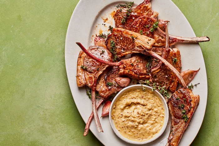 Plate of lamb cutlets with a dipping sauce in a bowl